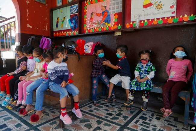 Anak-anak di Kathmandu, Nepal menunggu sebelum masuk kelas, setelah sekolah dibuka kembali setelah ditutup selama berbulan-bulan akibat pandemi, 27 September 2021.