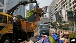 Polisi mencabut tenda-tenda para pemrotes dan membersihkan jalan-jalan utama kota Hong Kong (14/10).