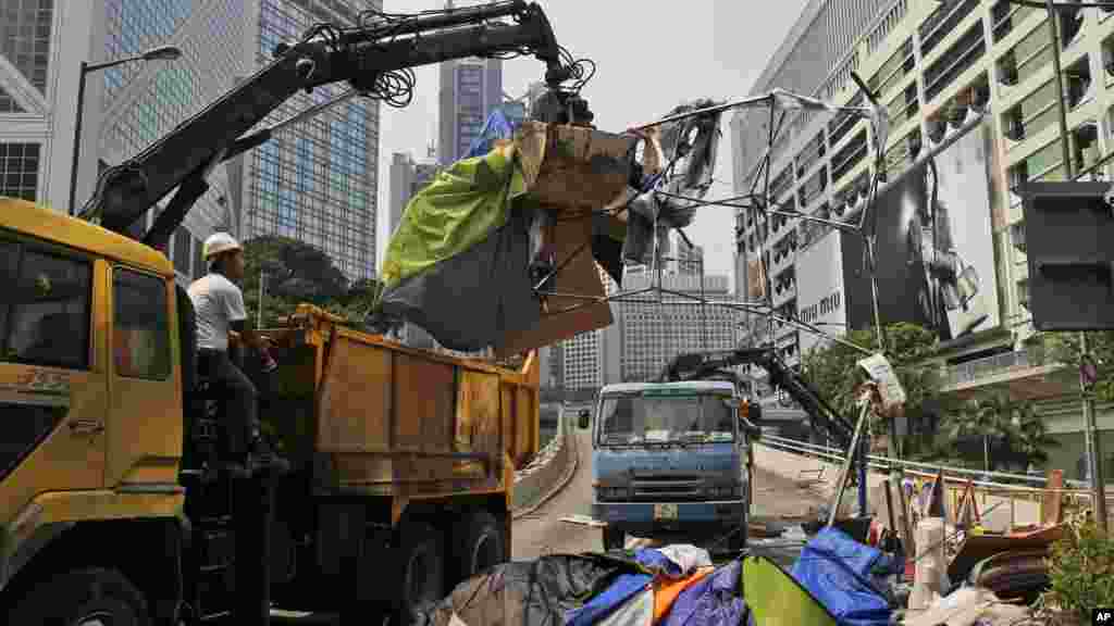 A l&#39;aide d&#39;une gure, des officiers de la police enlèvent des tentes des manifestants sur l&rsquo;avenue principale du district central de Hong Kong, le 14 octobre 2014. (AP Photo/Kin Cheung) 