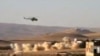 This citizen journalist image provided by Shaam News Network purports to show a helicopter gunship flying a bombing run in al-Qalmoun, Syria, July 24, 2012.