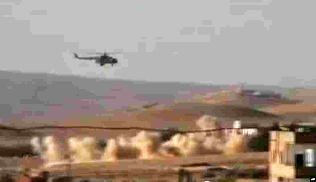 This citizen journalism image provided by Shaam News Network purports to show a helicopter gunship flying a bombing run in al-Qalmoun, Syria, July 24, 2012.