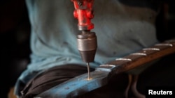 Guitar luthier Misoko Nzalayala Jean-Luther, alias Socklo, 61, works at his workshop in Kinshasa, Democratic Republic of Congo, Oct. 18, 2021.