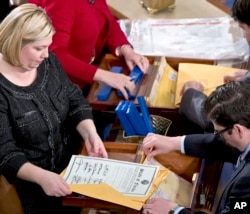 FILE - clerks unseal the certificates of results from all fifty states during a meeting of the U.S. Electoral College in the House of Representatives on Capitol in Washington.