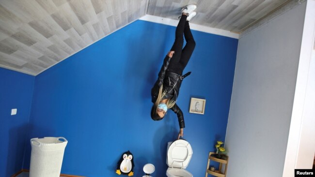 A woman poses for a photo inside the upside down house, in Guatavita, Colombia, January 23, 2022. Picture taken January 23, 2022. REUTERS/Luisa Gonzalez