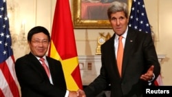 U.S. Secretary of State John Kerry (R) shakes hands with Vietnamese Deputy Prime Minister and Foreign Minister Pham Binh Minh before a working lunch at the State Department in Washington October 2, 2014. 