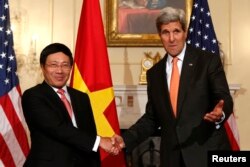 FILE - U.S. Secretary of State John Kerry (right) shakes hands with Vietnamese Deputy Prime Minister and Foreign Minister Pham Binh Minh at the State Department in Washington, Oct. 2, 2014.