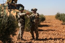 FILE - U.S. and Turkish soldiers discuss details during the first-ever combined joint patrol in Manbij, Syria, Nov. 1, 2018. (Courtesy: Arnada Jones/U.S. Army/Handout)