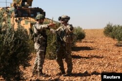 FILE - U.S. and Turkish soldiers discuss details during the first-ever combined joint patrol in Manbij, Syria, Nov. 1, 2018. (Courtesy: Arnada Jones/U.S. Army/Handout)