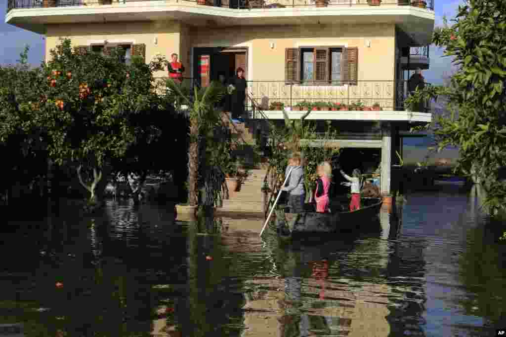 Children use a dinghy outside a flooded house after heavy rainfalls in Obot village, about 100 kilometres (60 miles) northwest of Tirana, Albania.