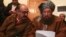 FILE- Maulana Sami ul-Haq (R), one of the Taliban negotiators, and Irfan Siddiqui, a government negotiator, discuss a joint statement before a news conference in Islamabad, Pakistan, Feb. 6, 2014.