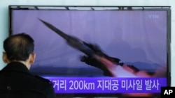 FILE - A South Korean man watches a TV news program showing file footage of a missile launch conducted by North Korea, in Seoul, South Korea, March 13, 2015.