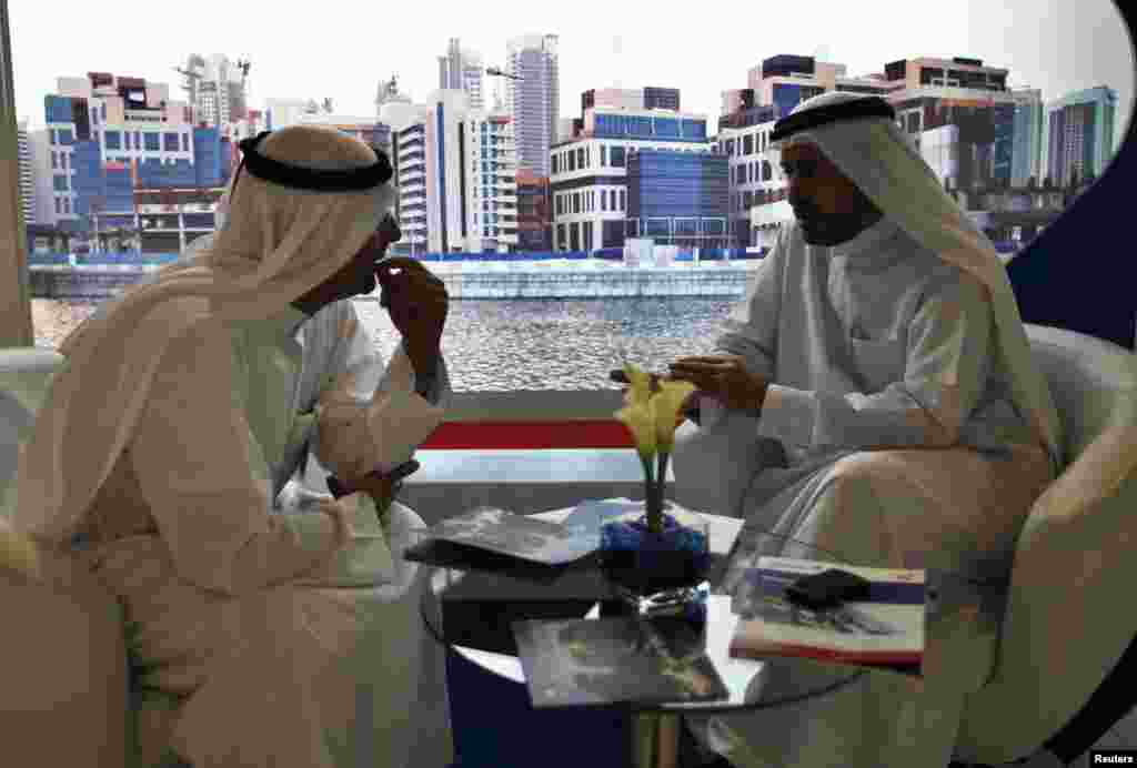 Businessmen speak to each other during the Cityscape real estate exhibition in Dubai October 2, 2012.
