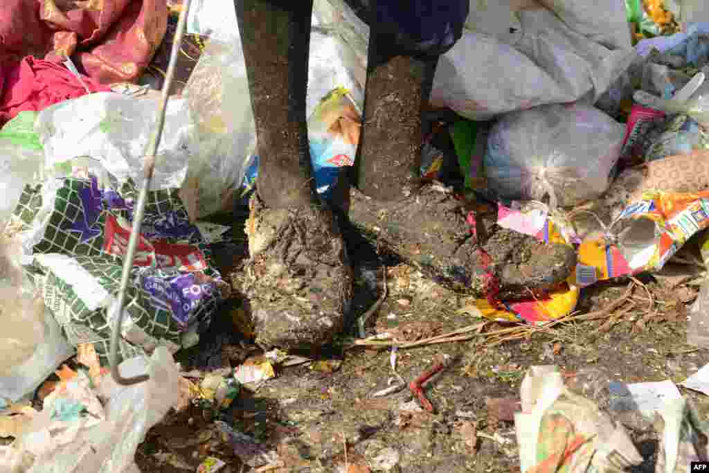 Hindistan Hayderabat&#39;ta geri dönüşüm çöplerini toplayan kadının ayakları