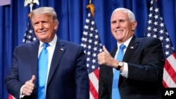 President Donald Trump and Vice President Mike Pence stand on stage during the first day of the 2020 Republican National Convention in Charlotte, N.C., Aug. 24, 2020. 