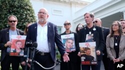Jonathan Dekel-Chen, second from left, father of American hostage Sagui Dekel-Chen, along with other families of hostages in Gaza, speaks to reporters outside the White house in Washington, April 9, 2024. 