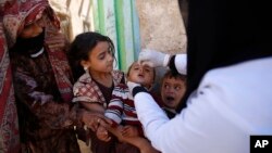 FILE - A boy receives a polio vaccination during a house-to-house polio immunization campaign in Sanaa, Yemen.