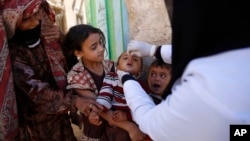 FILE - A boy receives a polio vaccination during a house-to-house polio immunization campaign in Sanaa, Yemen.