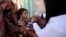 FILE - A boy receives a polio vaccination during a house-to-house polio immunization campaign in Sanaa, Yemen.