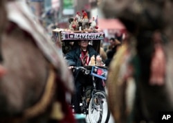 FILE - Luis Cajigas, 82, rides his tricycle decorated with religious and cultural symbols in the procession marking the 35th Anniversary of the Three Kings Parade in East Harlem, New York, Jan. 6, 2012.