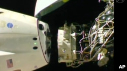 In this image taken from NASA Television, SpaceX's swanky new crew capsule undocks from the International Space Station Friday, March 8, 2019. (NASA TV via AP)