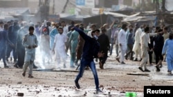 Pendukung partai politik Islam Tehreek-e-Labaik Pakistan (TLP) melemparkan batu ke arah polisi saat protes terhadap penangkapan pemimpin mereka di Lahore, Pakistan 13 April 2021, sebagai ilustrasi. (Foto: Reuters)