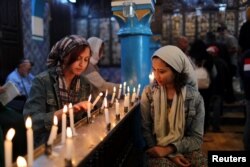 Cyrine Ben Said, left, and Amnia Ben Khalif, Muslim Tunisians, light candles during a religious ceremony at Ghriba, the oldest Jewish synagogue in Africa, during an annual pilgrimage in Djerba, Tunisia, May 2, 2018.