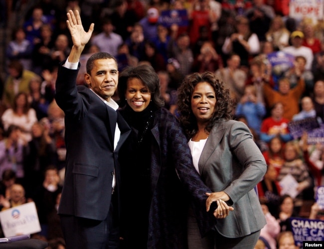 FILE - Democratic presidential candidate U.S. Senator Barack Obama, left, his wife Michelle, center, and talk show host Oprah Winfrey wave to the crowd at a campaign rally in Manchester, New Hampshire, Dec. 9, 2007.