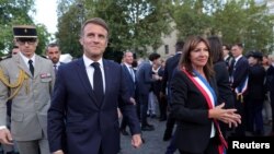 FILE - French President Emmanuel Macron and Paris Mayor Anne Hidalgo attend a ceremony to commemorate the 80th anniversary of the Liberation of Paris next to the Denfert Rocherau Square in Paris, Aug. 25, 2024.