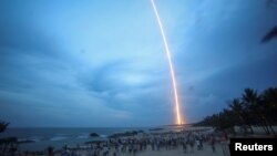 People watch the launch of the Long March-5 Y2 rocket from Wenchang Satellite Launch Center in Wenchang, Hainan Province, China, July 2, 2017. 