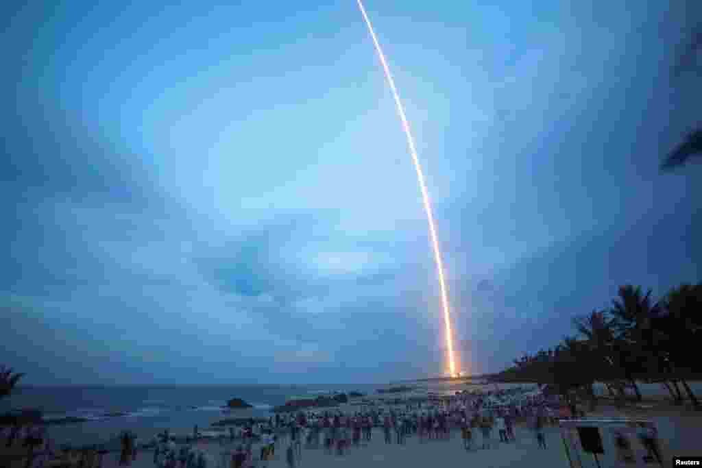 People watch the launch of the Long March-5 Y2 rocket from Wenchang Satellite Launch Center in Wenchang, Hainan Province, China.