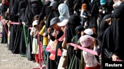Women and girls queue for Iftar (breaking of fast) meals supplied by a local charity during the holy month of Ramadan in Sana'a, Yemen June 12, 2016. 