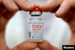 Seorang apoteker memegang botol vaksin Moderna di West Haven, Connecticut, AS, 17 Februari 2021. (Foto: REUTERS/Mike Segar)