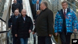 Russian President Vladimir Putin, foreground left, and Railways Chief Vladimir Yakunin, second right, visit the Olympic Park railway station at the Black Sea resort of Sochi, southern Russia, Jan. 4, 2014.