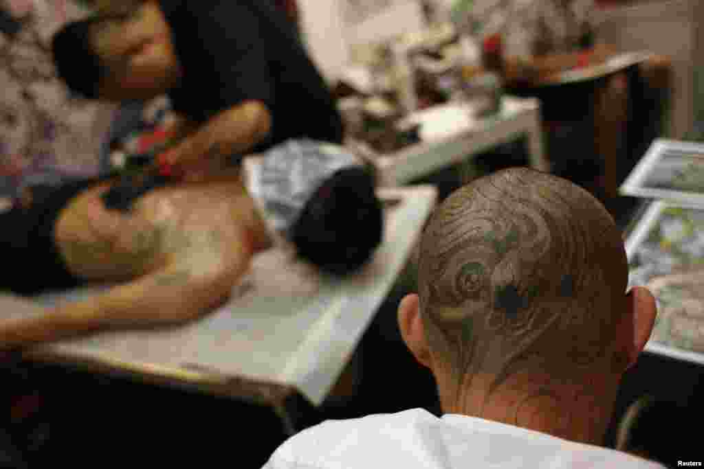 A man with tattoo on his head sits inside a booth at the International Hong Kong China Tattoo Convention.&nbsp; The territory held its second international tattoo convention, hoping to change the perception of tattoos in a city where inked skin is still strongly associated with triads and criminals.