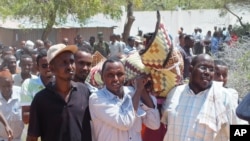 Mourners carry the body of Somali lawmaker Abdiaziz Isaq Mursal for burial in the Somali capital, Mogadishu, April 22, 2014.