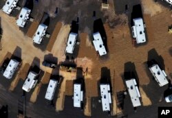 A worker sprays straw around newly setup Federal Emergency Management Agency trailers for residents left homeless by Hurricane Michael in Panama City, Fla, Thursday, Jan. 24, 2019.