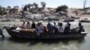 FILE - Ethiopians fleeing from the Tigray region arrive by boat to Sudan after crossing a river between the two countries, near the Hamdayet refugee transit camp, Sudan, Dec. 1, 2020. 