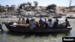 FILE - Ethiopians fleeing from the Tigray region arrive by boat to Sudan after crossing a river between the two countries, near the Hamdayet refugee transit camp, Sudan, Dec. 1, 2020. 