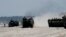 FILE - Amphibious Assault Vehicles, carrying American and Philippine troops, are seen on a beach during "Balikatan 2019" exercices, April 11, 2019, off San Antonio, Zambales province, northwest of Manila, Philippines. 