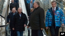 ປະທານາທິບໍດີຣັດເຊຍ ທ່ານ Vladimir Putin (ແຖວໜ້າຊ້າຍ) ແລະຫົວໜ້າການລົດໄຟ ຂອງຣັດເຊຍ ທ່ານ Vladimir Yakunin (ທີສອງຈາກຂວາ) ຢ້ຽມຢາມສະຖານີລົດໄຟ ຢູ່ບ່ອນແຂ່ງຂັນ ກິລາໂອລິມປິກ ໃນເມືອງ Sochi ຊຶ່ງເປັນເມືອງຕາກອາກາດ ແຄມທະເລດຳ ໃນພາກໃຕ້ຣັດເຊຍ (4 ມັງກອນ 2014)