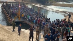 FILE - In this photo released by Royal Thai Army, more than 250 people from 20 nations who were reportedly rescued from alleged scam centers in Myanmar, are seen as they cross into Thailand's Tak province on Feb. 12, 2025. 