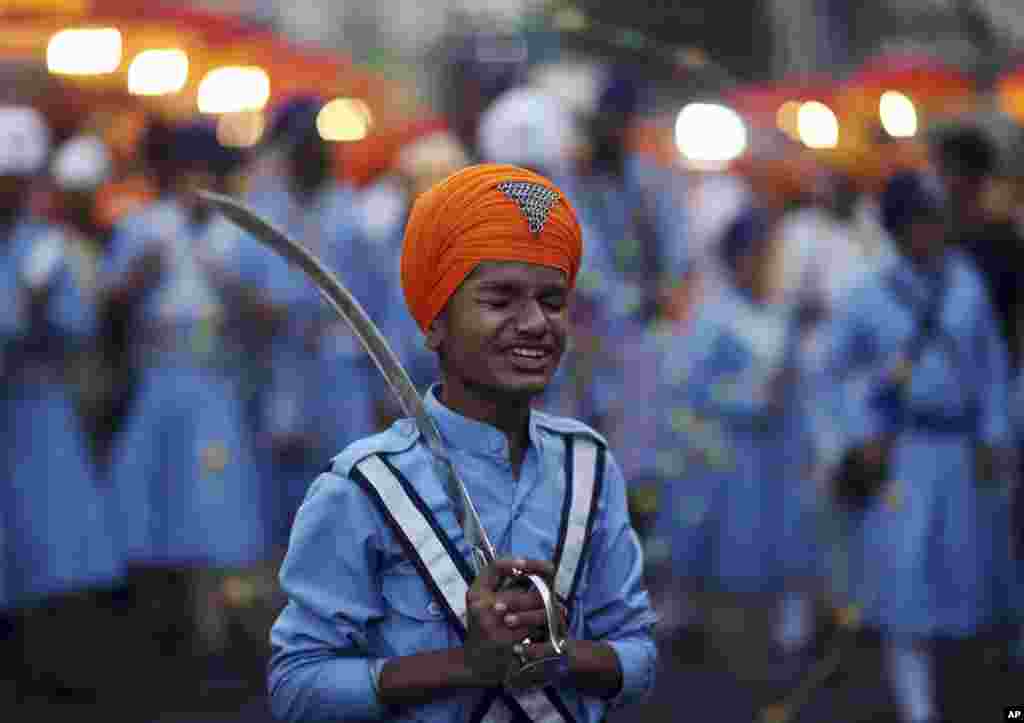 A Sikh boy reacts to a funny comment from another as he prepares to display his martial art skills during a religious procession ahead of the birth anniversary of the first Sikh guru, Guru Nanak, in Hyderabad, India.