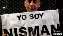 Marcelo Novillo, whose son Adrian was a victim of a violent crime, cries as he holds up a sign that reads "I am Nisman" outside the office of the prosecutor who is investigating the death of prosecutor Alberto Nisman in Buenos Aires, Jan. 22, 2015. 