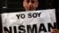 Marcelo Novillo, whose son Adrian was a victim of a violent crime, cries as he holds up a sign that reads "I am Nisman" outside the office of the prosecutor who is investigating the death of prosecutor Alberto Nisman in Buenos Aires, Jan. 22, 2015. 