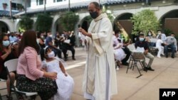 26일 미국 로스앤젤레스의 한 성당에서 신종 코로나바이러스 방역을 위해 야외 세례식이 열렸다.