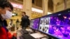 A staff member wearing a mask monitors thermal scanners that detect temperatures of passengers at the security check inside the Hankou Railway Station in Wuhan, China, Jan. 21, 2020. 