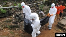 Health workers remove the body of a 29-year-old man who local residents say died of Ebola in Monrovia, Liberia, Sept. 11, 2014.