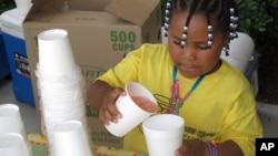 FILE - Harmonie Fredrick pours lemonade at a stand in Columbia, S.C., May 25, 2011. In North Carolina, authorities have arrested a man suspected of robbing a young lemonade vendor at gunpoint.