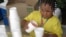 FILE - Harmonie Fredrick pours lemonade at a stand in Columbia, S.C., May 25, 2011. In North Carolina, authorities have arrested a man suspected of robbing a young lemonade vendor at gunpoint.