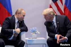 FILE - Russia's President Vladimir Putin talks to U.S. President Donald Trump during their bilateral meeting at the G20 summit in Hamburg, Germany, July 7, 2017.